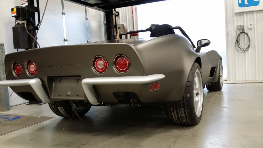 sleek gray corvette with red rear lights