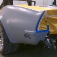 A 1968-1973 CORVETTE REAR FENDERS - 2" FLARE is being painted in a garage.