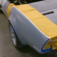 A 1968-1973 CORVETTE REAR FENDERS - 2" FLARE is being painted in a garage.