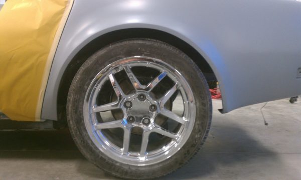A 1968-1973 CORVETTE REAR FENDERS - 2" FLARE with a yellow rim and a yellow tire.