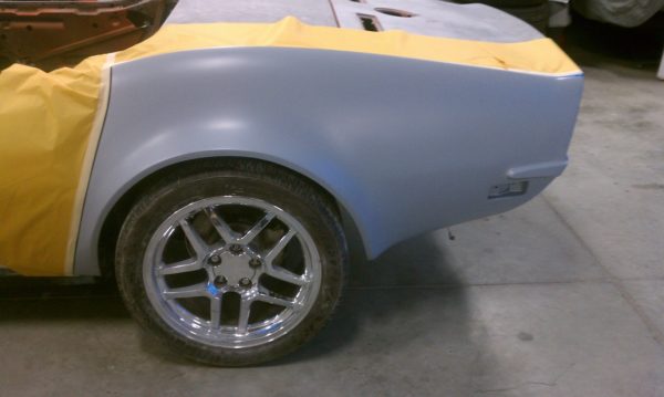 1968-1973 CORVETTE REAR FENDERS - 2" FLARE are being painted in a garage.