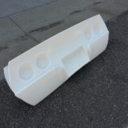 A white plastic 1968-1982 CORVETTE REAR TAILLAMP PANEL - GRAFT ON on the side of a street.