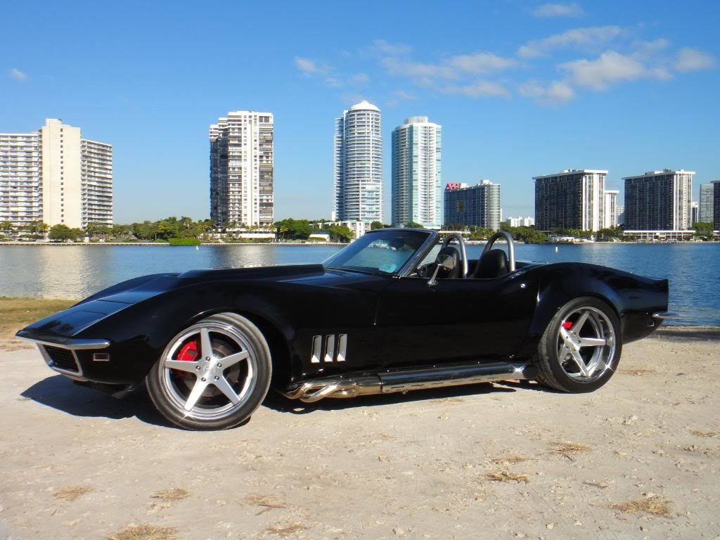 black corvette parked on a beach 4