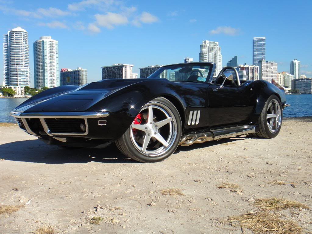 black corvette parked on a beach 2