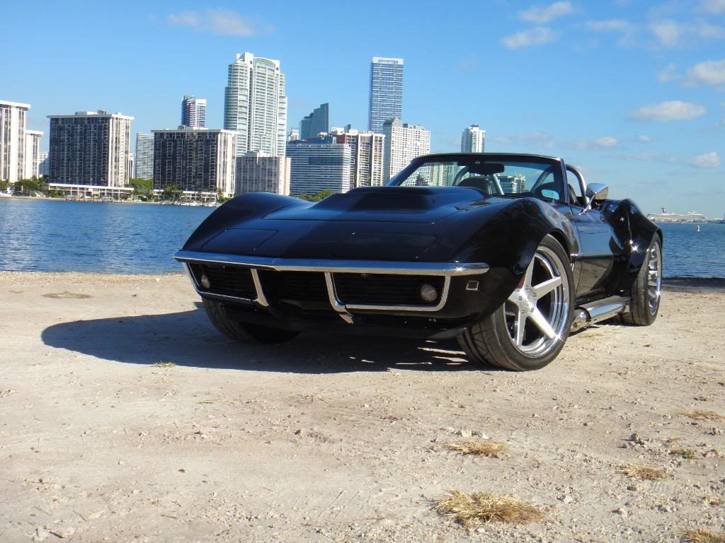 black corvette parked on a beach