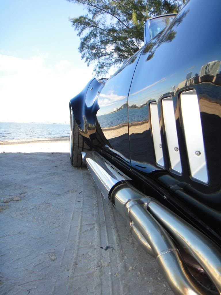 black corvette with chrome trim on sand