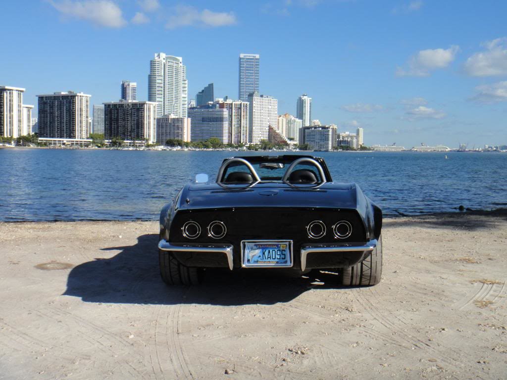 black corvette parked on a beach 10