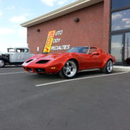 A red sports car parked in front of a building.