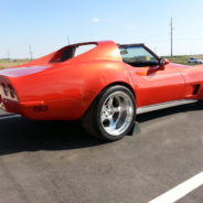 A red corvette parked in a parking lot.