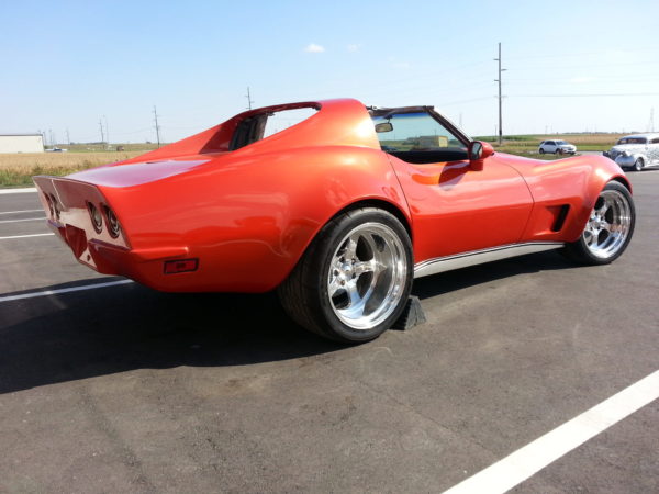 A red corvette parked in a parking lot.
