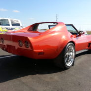 A red corvette parked in a parking lot.