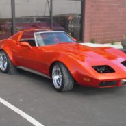 A red corvette parked in a parking lot.