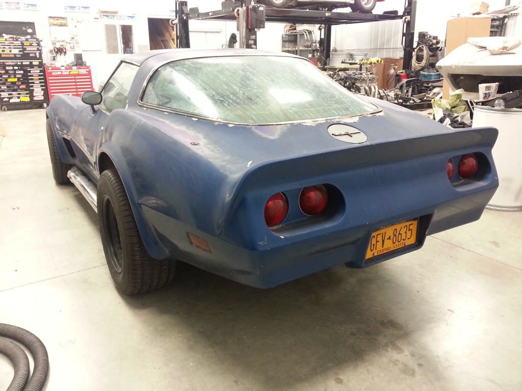 A blue corvette parked in a garage.