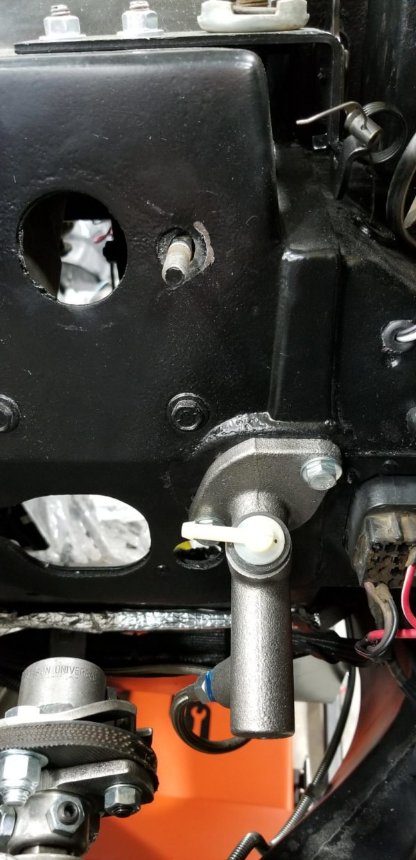 A close up of a C3 CORVETTE HYDRAULIC CLUTCH MASTER CYLINDER attached to a vehicle.