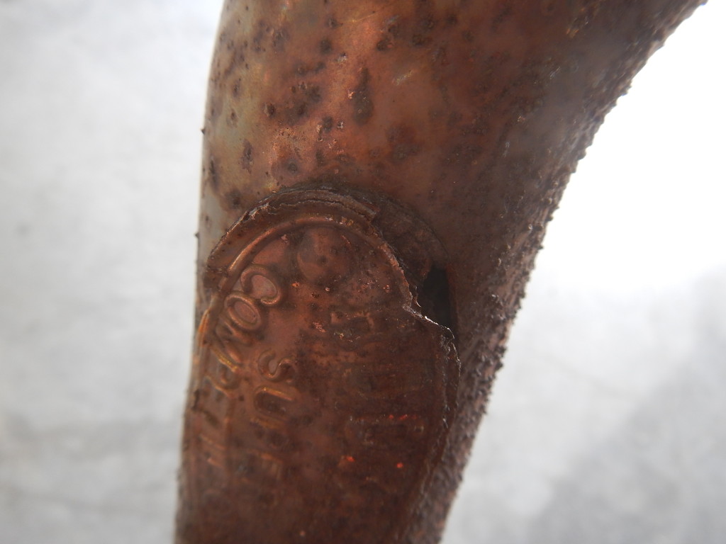 A close up of a copper pipe with rust on it.