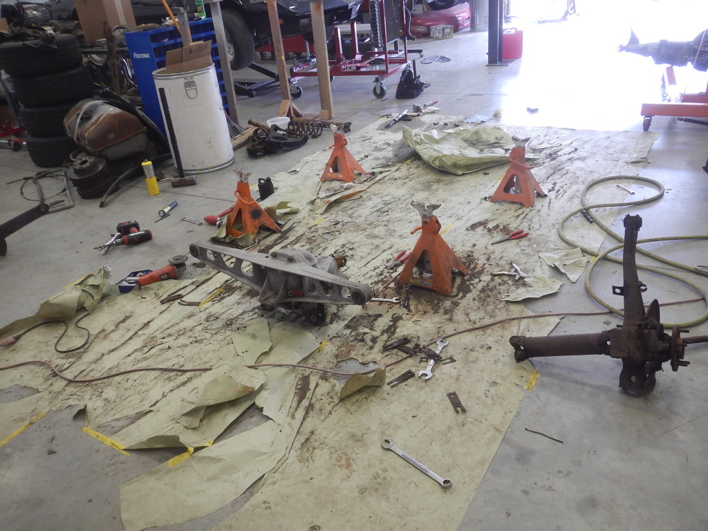 A bunch of tools on the floor of a garage.