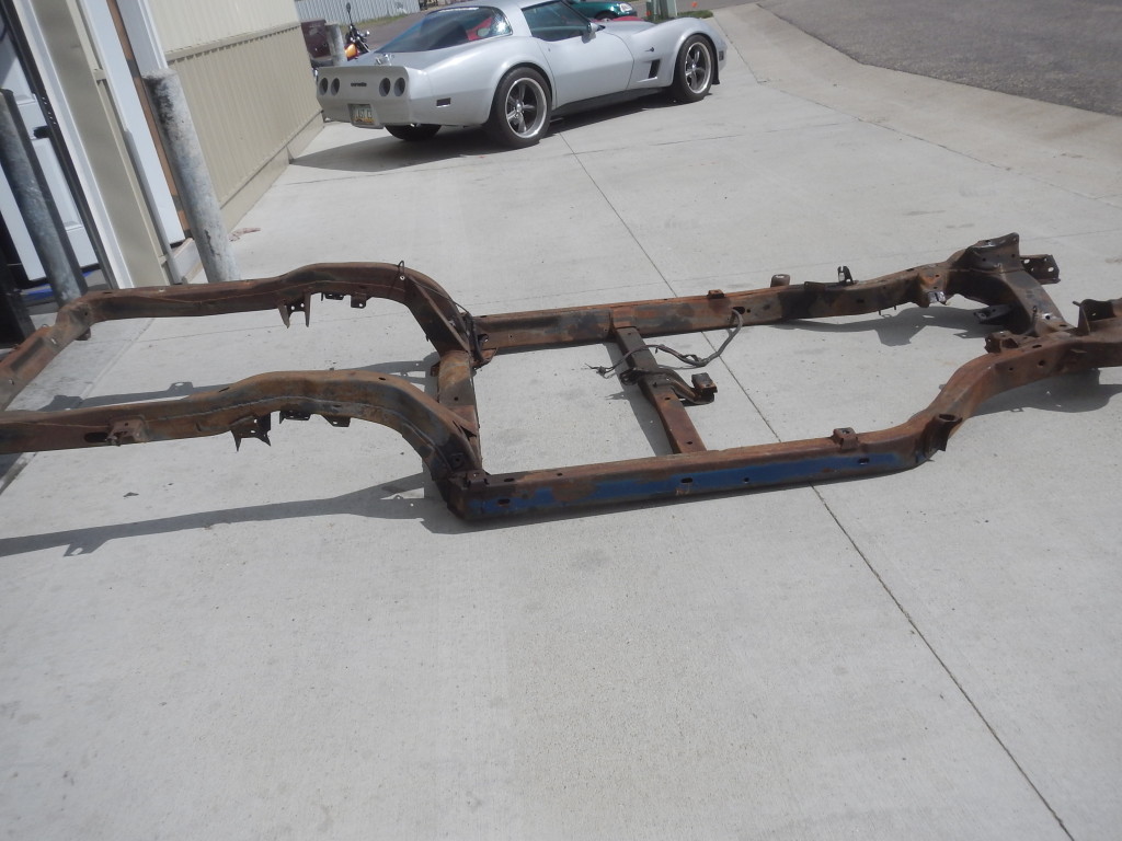 A rusted frame with a car on it.