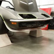 A 1968-1972 FRONT SPOILER - SS sitting on a lift in a garage.