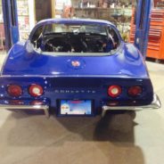 A blue 1974-1982 CORVETTE CHROME BUMPER CONVERSION KIT - STOCK REAR FENDERS parked in a garage.