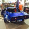 A blue 1974-1982 Corvette Chrome Bumper Conversion Kit - Stock Rear Fenders sitting in a garage.
