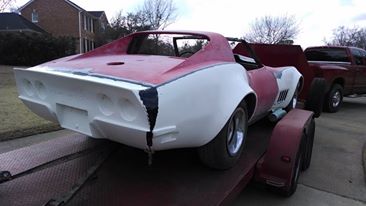 red corvette with lower part covered for customization