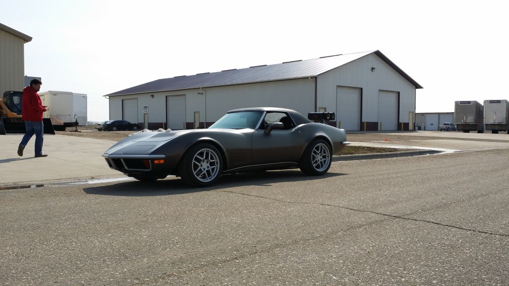 gray corvette parked in front of warehouse