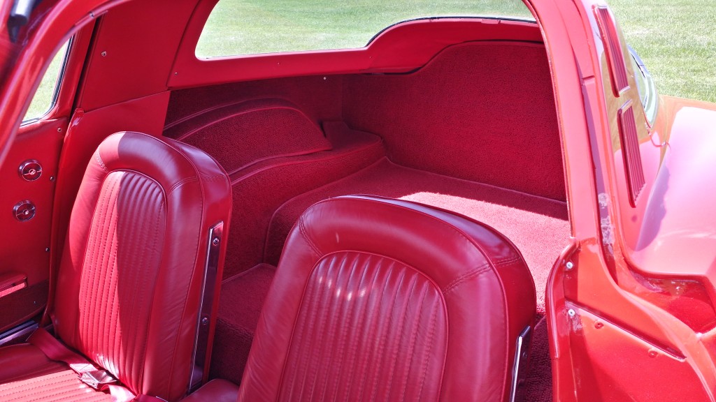 The interior of a red sports car with two seats.