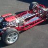 A red SRIII 1953-1962 ROUND TUBE FRAME race car with a large engine.