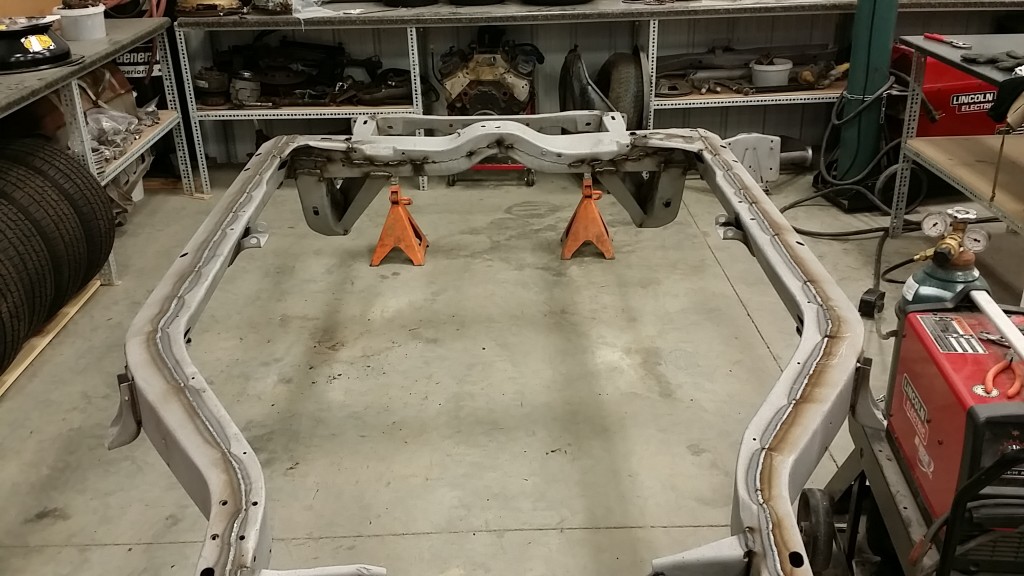 A car frame is being worked on in a garage.