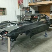 A black 1967 Corvette Replica Roadster sitting in a garage.