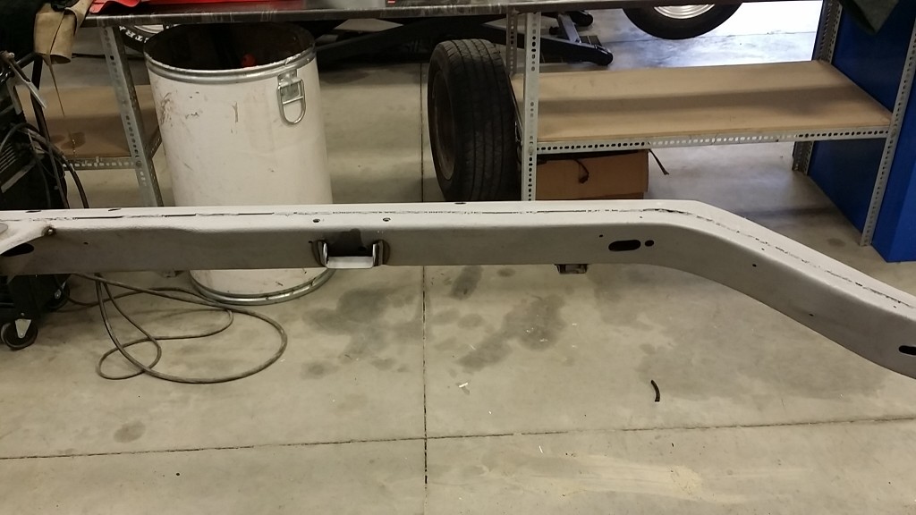 The rear bumper of a car in a garage.