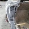 The back of a 1963-1967 Corvette Replica Coupe is being painted in a workshop.