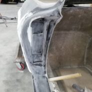 The back of a 1963-1967 Corvette Replica Coupe is being painted in a workshop.