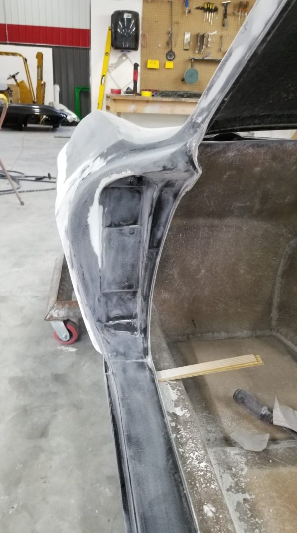 The back of a 1963-1967 Corvette Replica Coupe is being painted in a workshop.