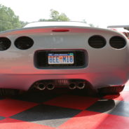 A grey C5 Wide Body Kit With Hood parked on a checkered floor.