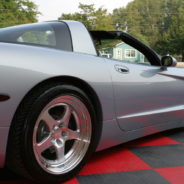 A silver C5 Wide Body Kit With Hood sports car sits on a checkered floor.