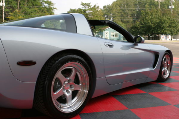 A silver C5 Wide Body Kit With Hood sports car sits on a checkered floor.