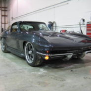 A black 1963-1967 Corvette Replica Coupe parked in a garage.