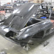 A black 1967 Corvette Replica Roadster in a garage with the hood open.