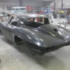 A 1963-1967 Corvette Replica Coupe sitting in a garage.