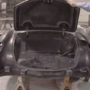 A black 1958-1960 Corvette Replica Body Kit with its trunk open in a factory.