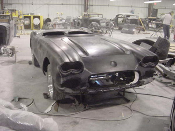 A 1958-1960 Corvette Replica Body Kit is being worked on in a garage.