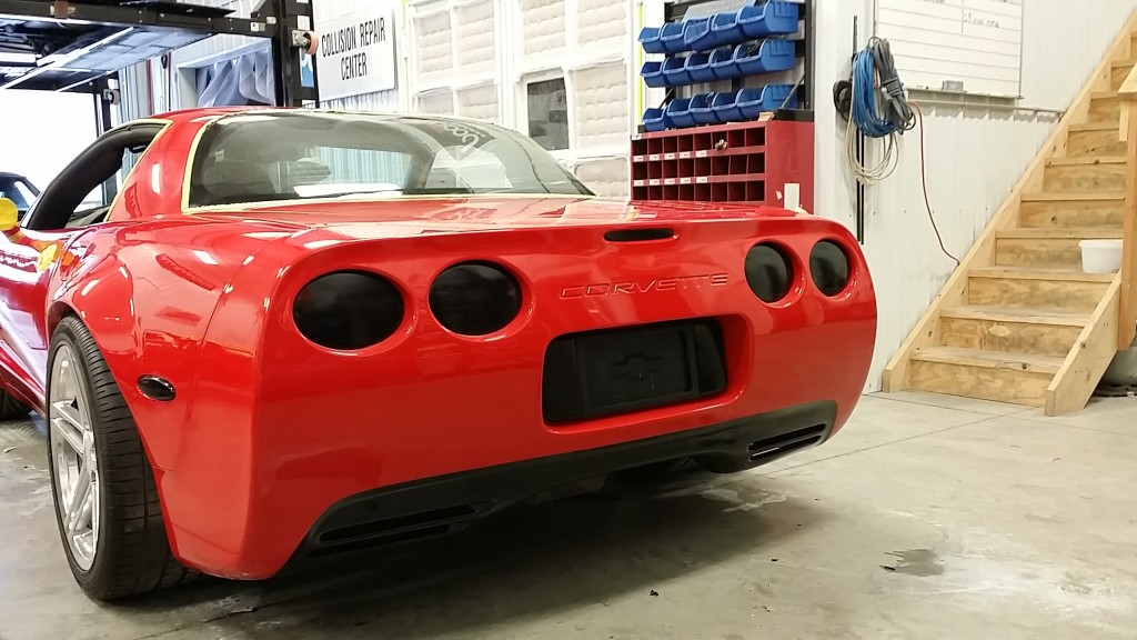 A red corvette parked in a garage.