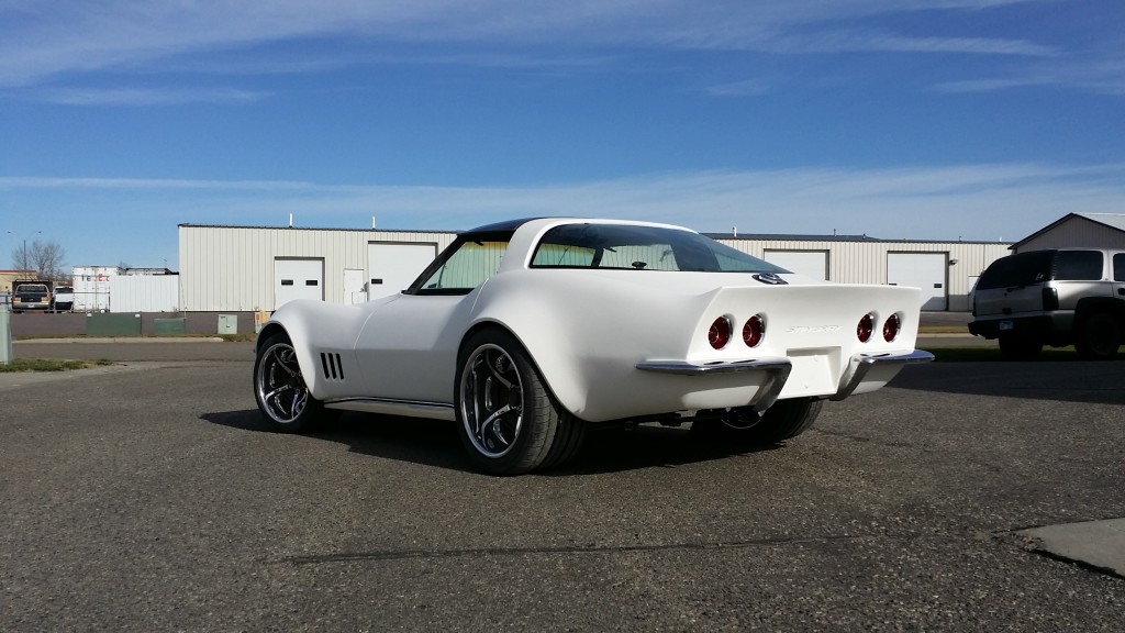 A white corvette parked in a parking lot.