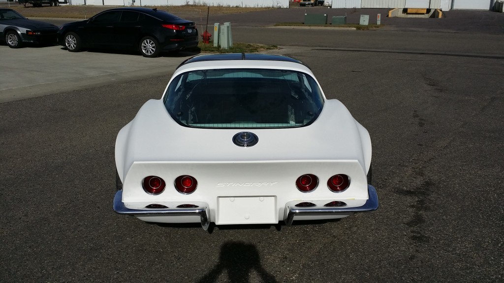 A white corvette parked in a parking lot.