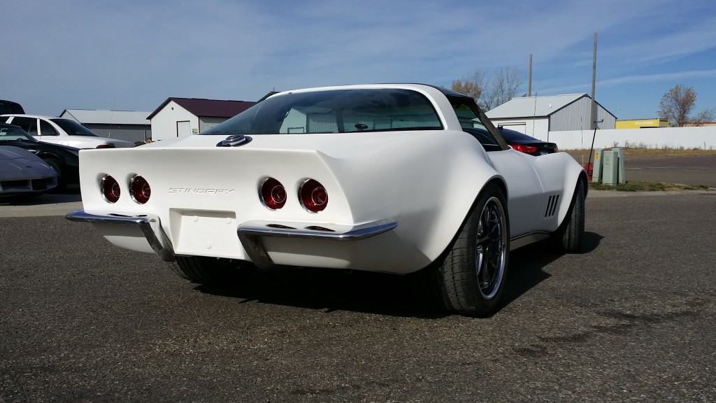 A white chevrolet corvette parked in a parking lot.