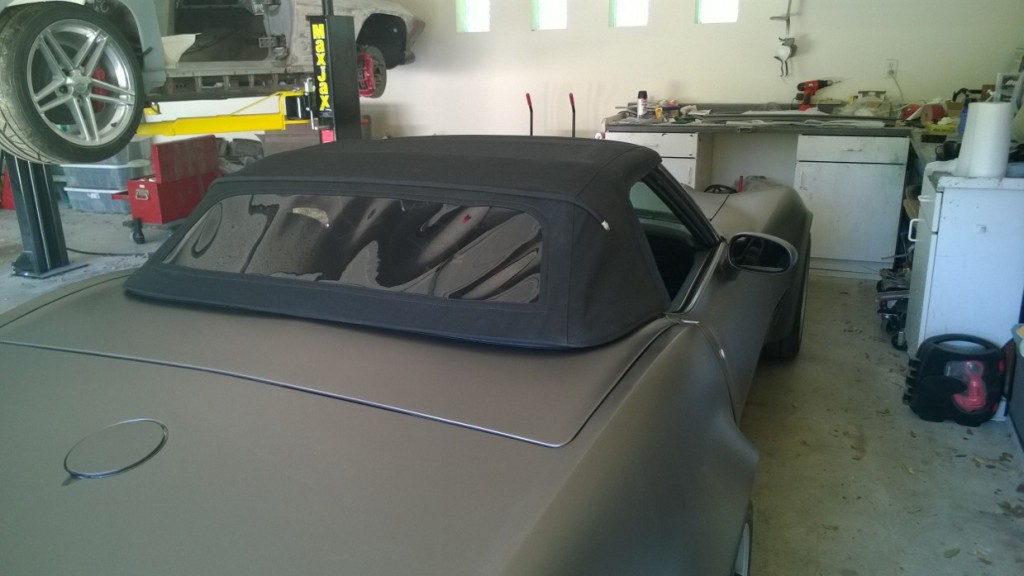 gray corvette with black top in full garage