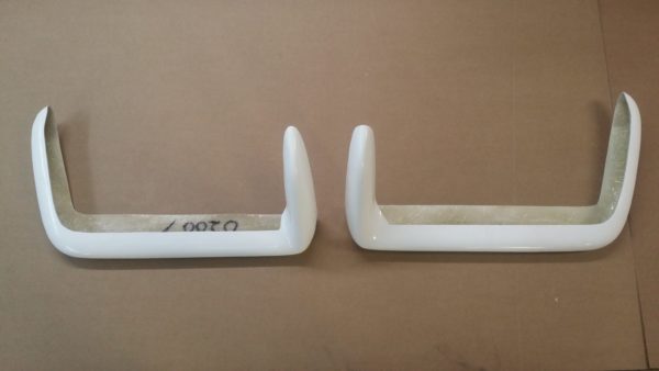 A pair of 1968-1973 REAR BUMPERS - FIBERGLASS on a table.
