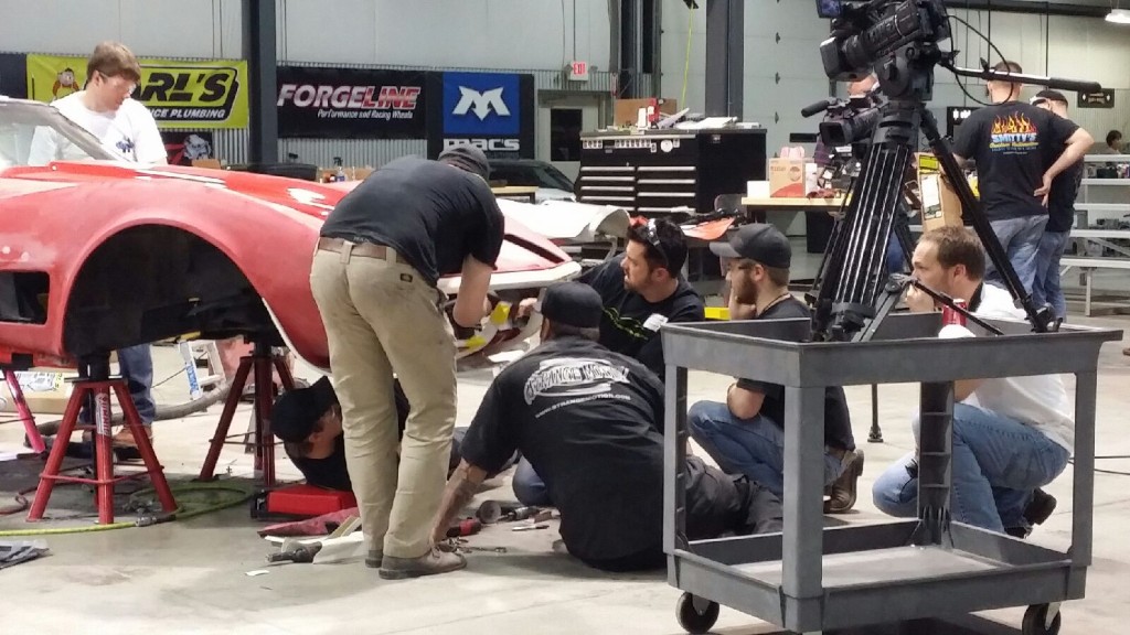 Workers working in a workshop on a car