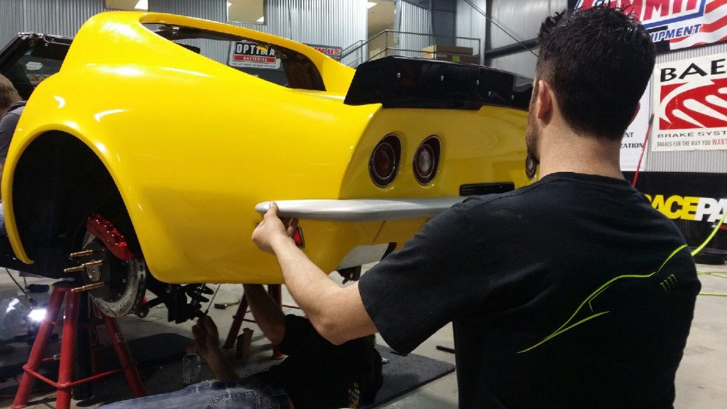 A worker working on a yellow color car